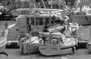 İtalya, Sicilya, Akdeniz, Marina di Ragusa (Ragusa ili); 7 Nisan 2022, limandaki insanlar ve yelkenliler - EDITORIAL