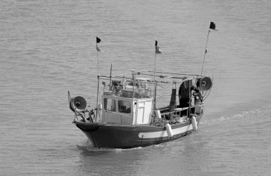 İtalya, Sicilya, Akdeniz, Marina di Ragusa (Ragusa Eyaleti); limandaki ahşap balıkçı teknesinde balıkçı. 