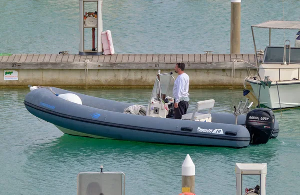 İtalya, Sicilya, Akdeniz, Marina di Ragusa (Ragusa Eyaleti); 24 Nisan 2022, limandaki kauçuk bir teknede adam - EDITORIAL