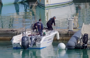 İtalya, Sicilya, Akdeniz, Marina di Ragusa (Ragusa Eyaleti); 26 Nisan 2022, limandaki bir motorlu teknede balıkçı - EDITORIAL