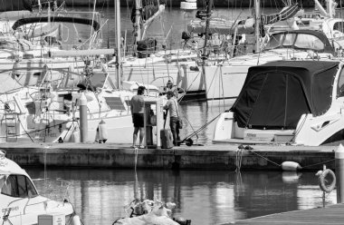 İtalya, Sicilya, Akdeniz, Marina di Ragusa (Ragusa Eyaleti); 17 Mayıs 2022, limandaki insanlar ve lüks yatlar - EDITORIAL