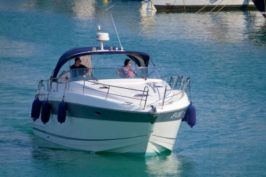 İtalya, Sicilya, Akdeniz, Marina di Ragusa (Ragusa ili); 19 Haziran 2022, limanda lüks bir yatta çift - EDITORIAL