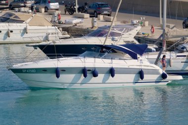 İtalya, Sicilya, Akdeniz, Marina di Ragusa (Ragusa ili); 19 Haziran 2022, limanda lüks bir yatta çift - EDITORIAL