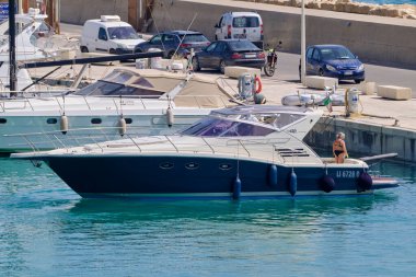 İtalya, Sicilya, Akdeniz, Marina di Ragusa (Ragusa Eyaleti); 26 Haziran 2022, limanda lüks bir yatta insanlar - EDITORIAL
