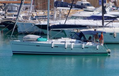 İtalya, Sicilya, Akdeniz, Marina di Ragusa (Ragusa Eyaleti); 15 Temmuz 2022, limandaki bir yelkenli ve lüks yatlarda yaşayan insanlar - EDITORIAL