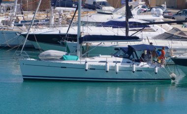 İtalya, Sicilya, Akdeniz, Marina di Ragusa (Ragusa Eyaleti); 15 Temmuz 2022, limandaki bir yelkenli ve lüks yatlarda yaşayan insanlar - EDITORIAL