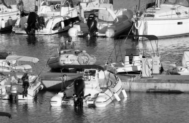 İtalya, Sicilya, Akdeniz, Marina di Ragusa (Ragusa Eyaleti); 15 Temmuz 2022, limandaki kauçuk tekne ve lüks yatlarda yaşayan insanlar - EDITORIAL