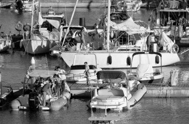 İtalya, Sicilya, Akdeniz, Marina di Ragusa (Ragusa ili); 16 Temmuz 2022, limandaki insanlar, motorlu tekneler ve lüks yatlar - EDITORIAL