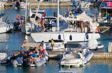 İtalya, Sicilya, Akdeniz, Marina di Ragusa (Ragusa ili); 16 Temmuz 2022, limandaki insanlar, motorlu tekneler ve lüks yatlar - EDITORIAL