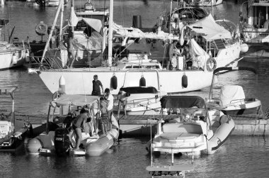 İtalya, Sicilya, Akdeniz, Marina di Ragusa (Ragusa ili); 16 Temmuz 2022, limandaki insanlar, motorlu tekneler ve lüks yatlar - EDITORIAL