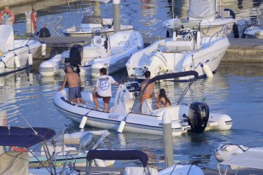 İtalya, Sicilya, Akdeniz, Marina di Ragusa (Ragusa Eyaleti); 19 Temmuz 2022, limandaki kauçuk tekne ve lüks yatlarda yaşayan insanlar - EDITORIAL