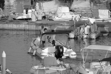 İtalya, Sicilya, Akdeniz, Marina di Ragusa (Ragusa Eyaleti); 19 Temmuz 2022, limandaki kauçuk tekne ve lüks yatlarda yaşayan insanlar - EDITORIAL