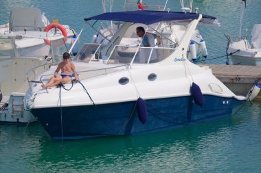 İtalya, Sicilya, Akdeniz, Marina di Ragusa (Ragusa Eyaleti); 21 Temmuz 2022, limanda lüks bir yatta insanlar - EDITORIAL