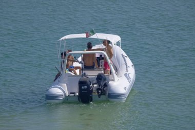 İtalya, Sicilya, Akdeniz, Marina di Ragusa (Ragusa Eyaleti); 23 Temmuz 2022, limandaki kauçuk bir teknede insanlar - EDITORIAL