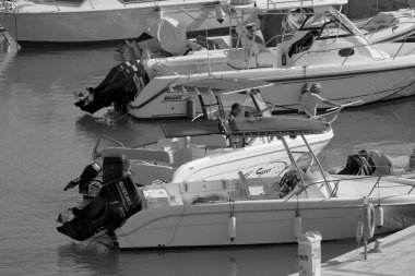 İtalya, Sicilya, Akdeniz, Marina di Ragusa (Ragusa Eyaleti); 25 Temmuz 2022, limandaki bir motorlu teknede balıkçı - EDITORIAL