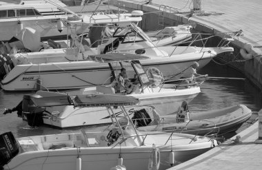 İtalya, Sicilya, Akdeniz, Marina di Ragusa (Ragusa Eyaleti); 25 Temmuz 2022, limandaki bir motorlu teknede balıkçı - EDITORIAL