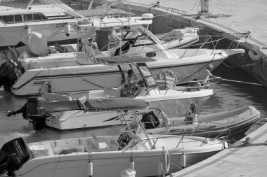 İtalya, Sicilya, Akdeniz, Marina di Ragusa (Ragusa Eyaleti); 25 Temmuz 2022, limandaki bir motorlu teknede balıkçı - EDITORIAL