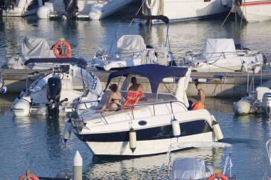 İtalya, Sicilya, Akdeniz, Marina di Ragusa (Ragusa Eyaleti); 29 Temmuz 2022, limanda lüks bir yatta insanlar - EDITORIAL