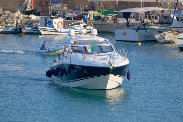 İtalya, Sicilya, Akdeniz, Marina di Ragusa (Ragusa ili); 30 Temmuz 2022, lüks bir yat ve limandaki yerel balıkçı tekneleri - EDITORIAL