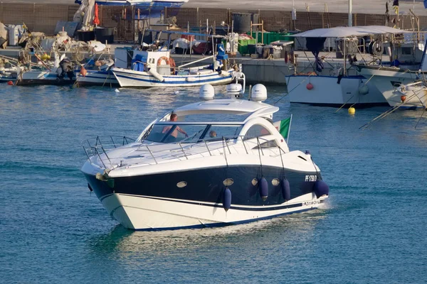 İtalya, Sicilya, Akdeniz, Marina di Ragusa (Ragusa ili); 30 Temmuz 2022, lüks bir yat ve limandaki yerel balıkçı tekneleri - EDITORIAL