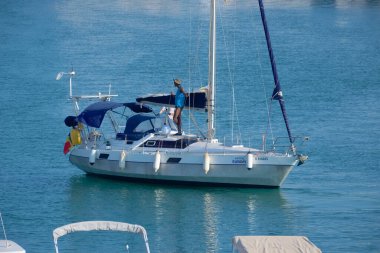 Italy, Sicily, Mediterranean Sea, Marina di Ragusa (Ragusa Province); 31 July 2022, men on a sailing boat and luxury yachts in the port - EDITORIAL