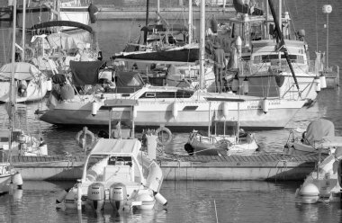 Italy, Sicily, Mediterranean Sea, Marina di Ragusa (Ragusa Province); 31 July 2022, men on a sailing boat and luxury yachts in the port - EDITORIAL