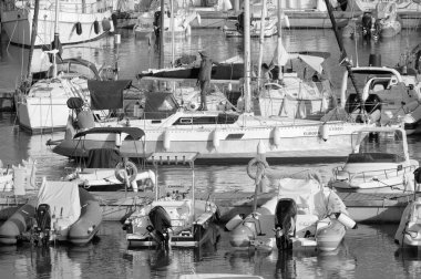 Italy, Sicily, Mediterranean Sea, Marina di Ragusa (Ragusa Province); 31 July 2022, men on a sailing boat and luxury yachts in the port - EDITORIAL