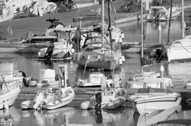 Italy, Sicily, Mediterranean Sea, Marina di Ragusa (Ragusa Province); 31 July 2022, men on a sailing boat and luxury yachts in the port - EDITORIAL