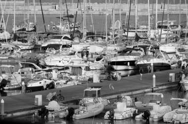 Italy, Sicily, Mediterranean sea, Marina di Ragusa (Ragusa Province); 1 August 2022, people, motor boats and luxury yachts in the port at sunset - EDITORIAL