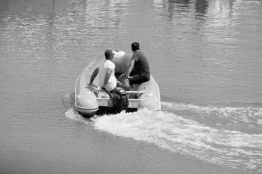 Italy, Sicily, Mediterranean Sea, Marina di Ragusa (Ragusa Province); 4 August 2022, men on a rubber boat in the port - EDITORIAL