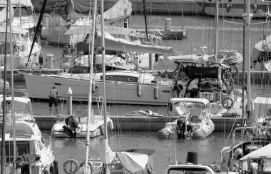 Italy, Sicily, Mediterranean Sea, Marina di Ragusa (Ragusa Province); 6 August 2022, people on a sailing boat, motor boats and luxury yachts in the port - EDITORIAL