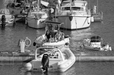 Italy, Sicily, Mediterranean Sea, Marina di Ragusa (Ragusa Province); 14 August 2022, people on a motor boat and luxury yachts in the port - EDITORIAL