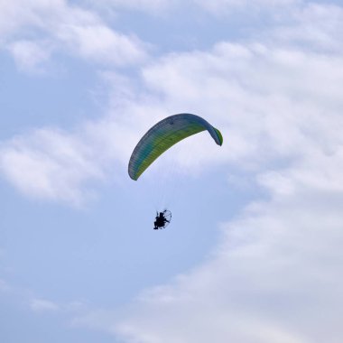 Italy; Sicily, man flying on a powered paraglider 