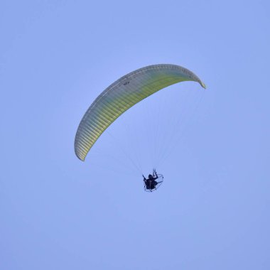 Italy; Sicily, man flying on a powered paraglider 