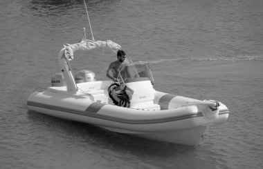 Italy, Sicily, Mediterranean Sea, Marina di Ragusa (Ragusa Province); 16 August 2022, man on a rubber boat in the port - EDITORIAL