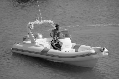 Italy, Sicily, Mediterranean Sea, Marina di Ragusa (Ragusa Province); 16 August 2022, man on a rubber boat in the port - EDITORIAL