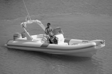 Italy, Sicily, Mediterranean Sea, Marina di Ragusa (Ragusa Province); 16 August 2022, man on a rubber boat in the port - EDITORIAL