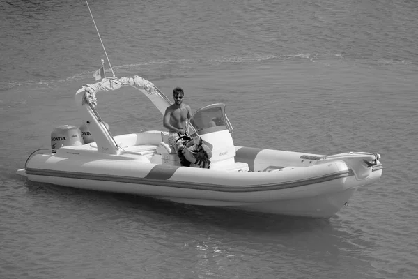 Italy, Sicily, Mediterranean Sea, Marina di Ragusa (Ragusa Province); 16 August 2022, man on a rubber boat in the port - EDITORIAL