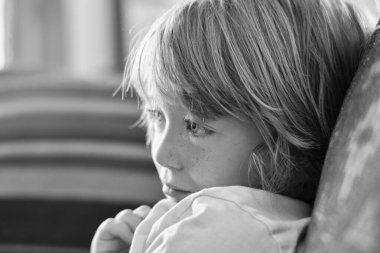 Italy, Sicily, Marina di Ragusa (Ragusa Province); portrait of a 6 years old male child on the couch of a living room
