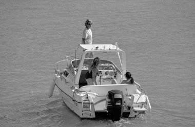 Italy, Sicily, Mediterranean Sea, Marina di Ragusa (Ragusa Province); 25 August 2022, people on a motor boat in the port - EDITORIAL