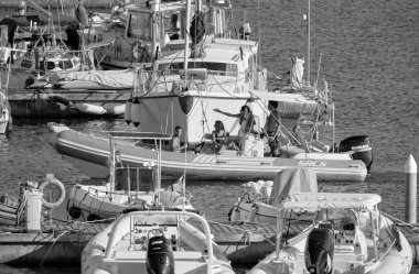 Italy, Sicily, Mediterranean Sea, Marina di Ragusa (Ragusa Province); 27 August 2022, people on a rubber boat and luxury yachts in the port - EDITORIAL