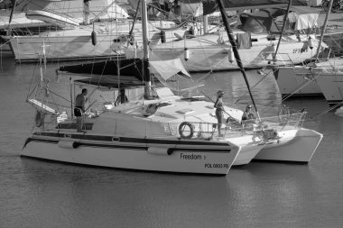 Italy, Sicily, Mediterranean Sea, Marina di Ragusa (Ragusa Province); 27 August 2022, people on a catamaran sailing boat and luxury yachts in the port - EDITORIAL