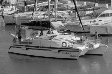 Italy, Sicily, Mediterranean Sea, Marina di Ragusa (Ragusa Province); 27 August 2022, people on a catamaran sailing boat and luxury yachts in the port - EDITORIAL