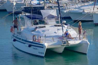 Italy, Sicily, Mediterranean Sea, Marina di Ragusa (Ragusa Province); 27 August 2022, people on a catamaran sailing boat and luxury yachts in the port - EDITORIAL