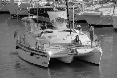 Italy, Sicily, Mediterranean Sea, Marina di Ragusa (Ragusa Province); 27 August 2022, people on a catamaran sailing boat and luxury yachts in the port - EDITORIAL