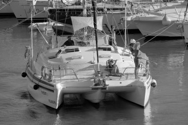 Italy, Sicily, Mediterranean Sea, Marina di Ragusa (Ragusa Province); 27 August 2022, people on a catamaran sailing boat and luxury yachts in the port - EDITORIAL