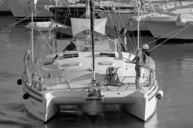 Italy, Sicily, Mediterranean Sea, Marina di Ragusa (Ragusa Province); 27 August 2022, people on a catamaran sailing boat and luxury yachts in the port - EDITORIAL
