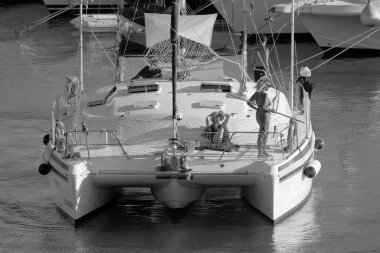 Italy, Sicily, Mediterranean Sea, Marina di Ragusa (Ragusa Province); 27 August 2022, people on a catamaran sailing boat and luxury yachts in the port - EDITORIAL
