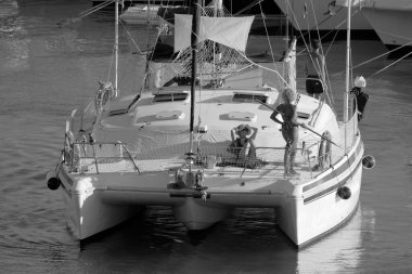 Italy, Sicily, Mediterranean Sea, Marina di Ragusa (Ragusa Province); 27 August 2022, people on a catamaran sailing boat and luxury yachts in the port - EDITORIAL