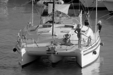 Italy, Sicily, Mediterranean Sea, Marina di Ragusa (Ragusa Province); 27 August 2022, people on a catamaran sailing boat and luxury yachts in the port - EDITORIAL